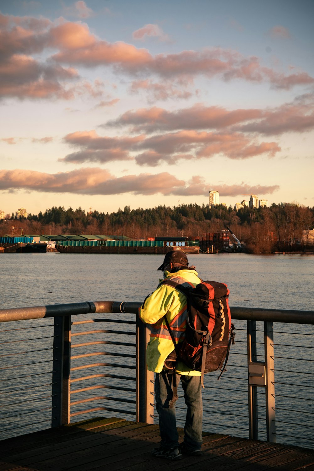 a man standing on a bridge looking at the water