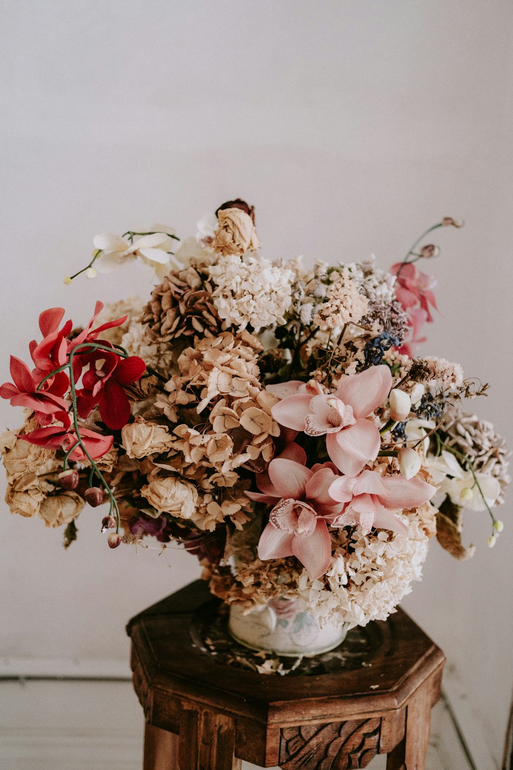 a vase filled with lots of flowers on top of a table