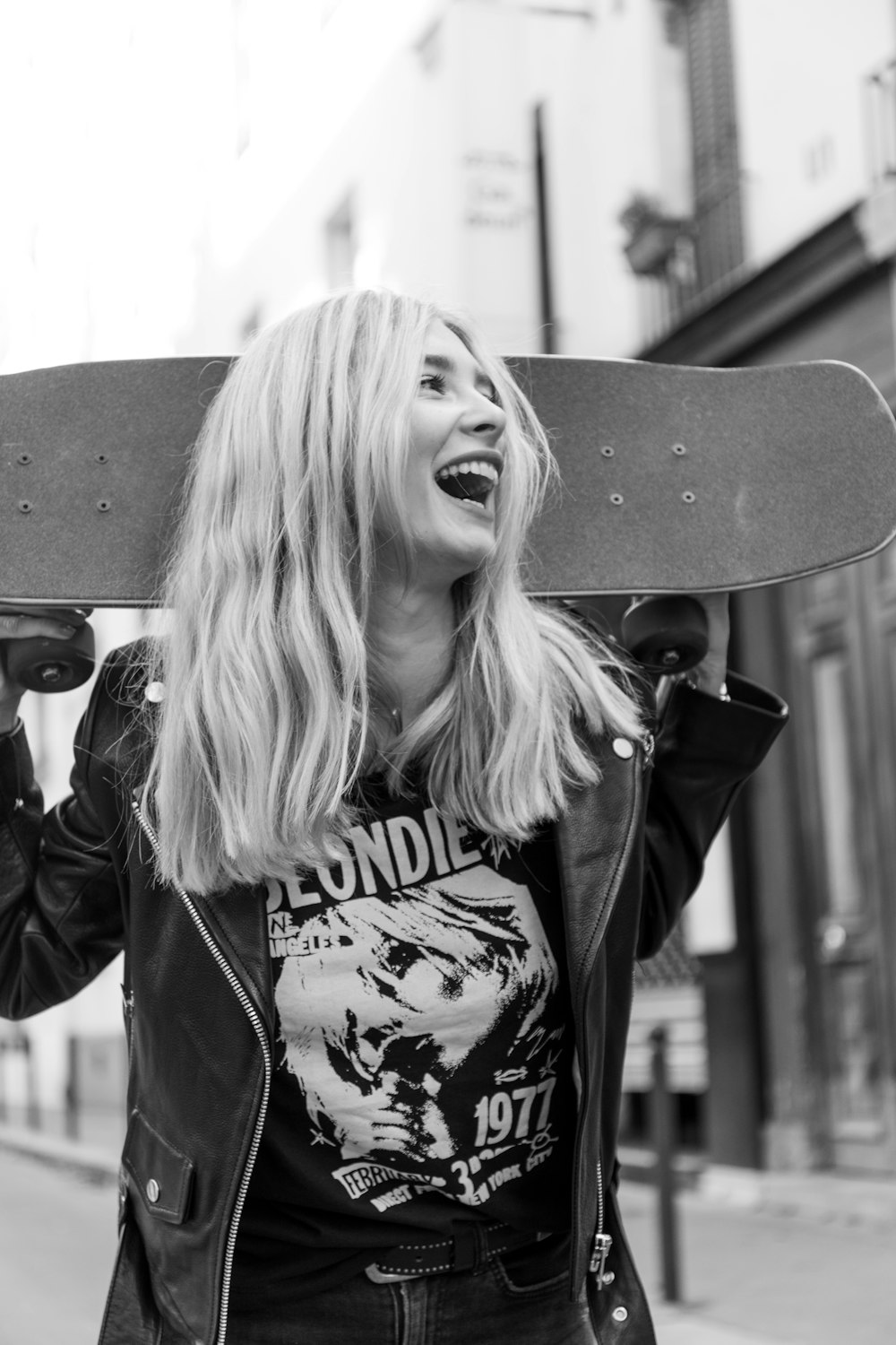 a woman holding a skateboard over her head