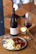 Close-up of a rustic cheese platter paired with a glass of red wine on a wooden table.