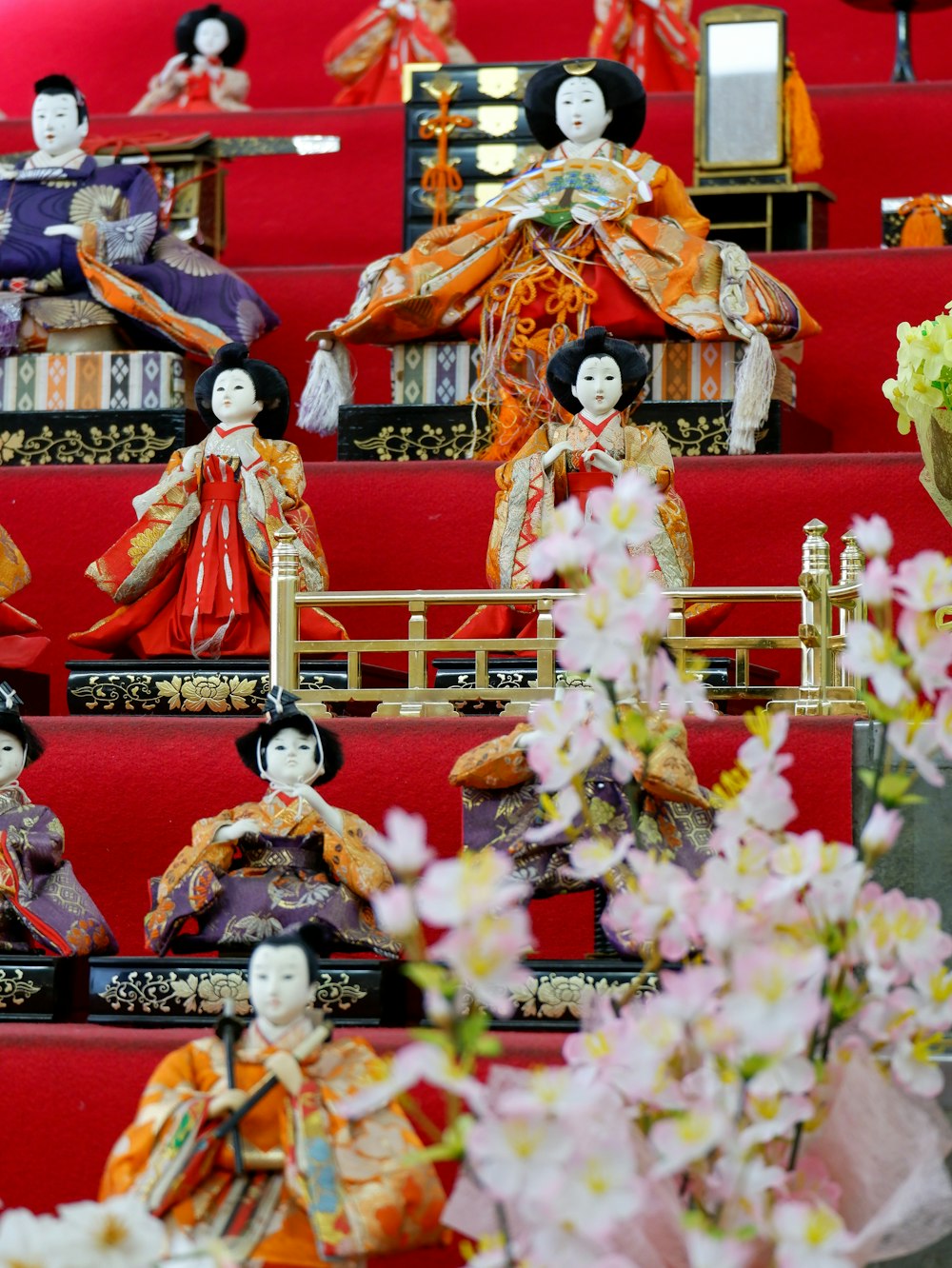 a group of dolls sitting on top of a red bench