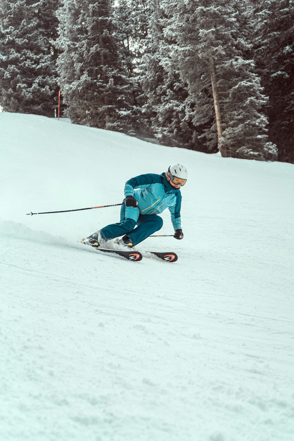 a person riding skis down a snow covered slope