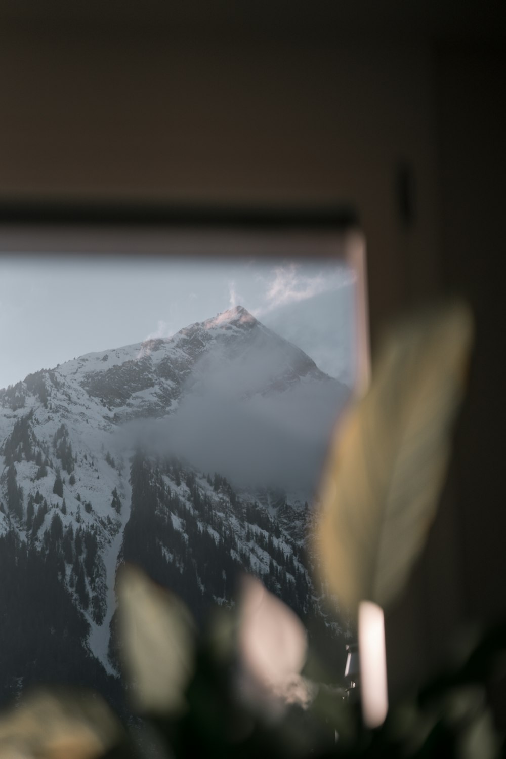 a view of a snowy mountain from a window