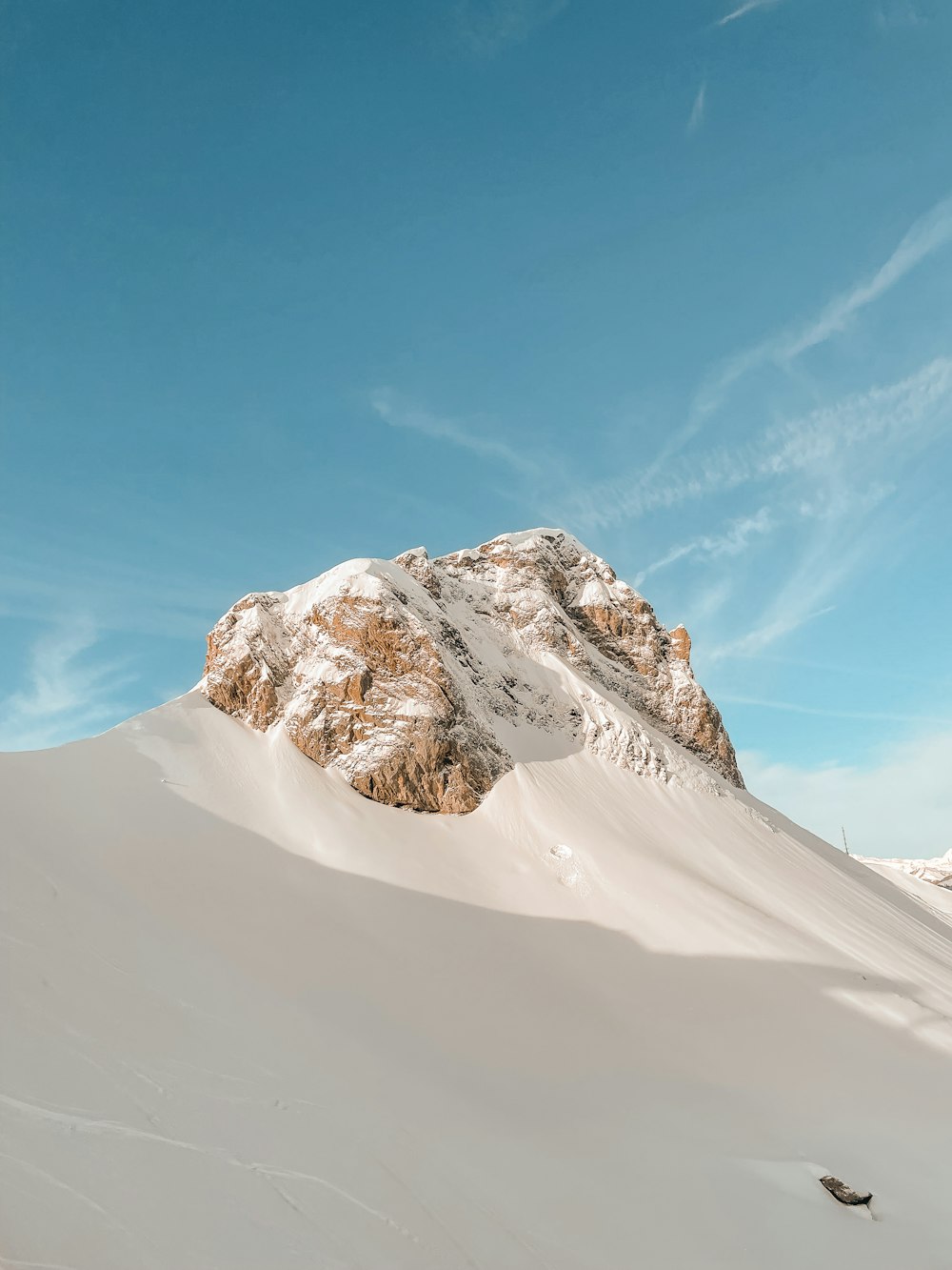 a snow covered mountain under a blue sky