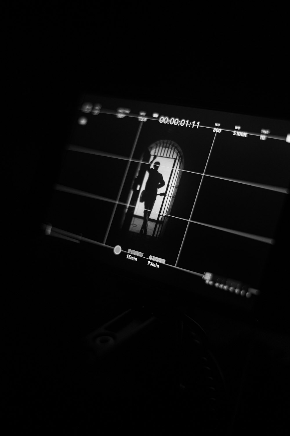 a black and white photo of a person standing in a doorway