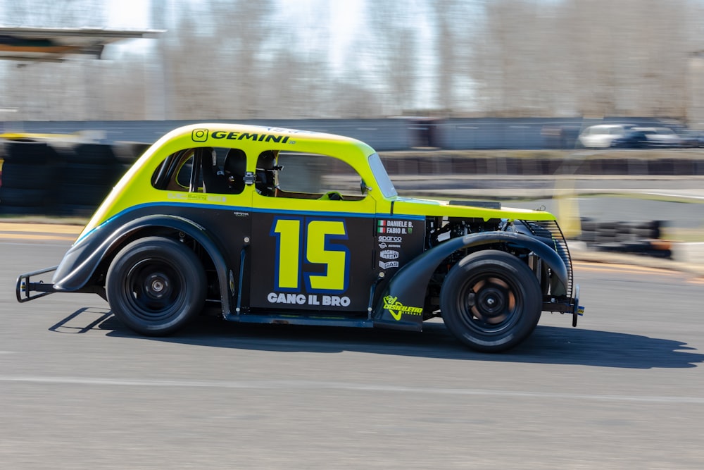 a yellow and black car driving down a race track