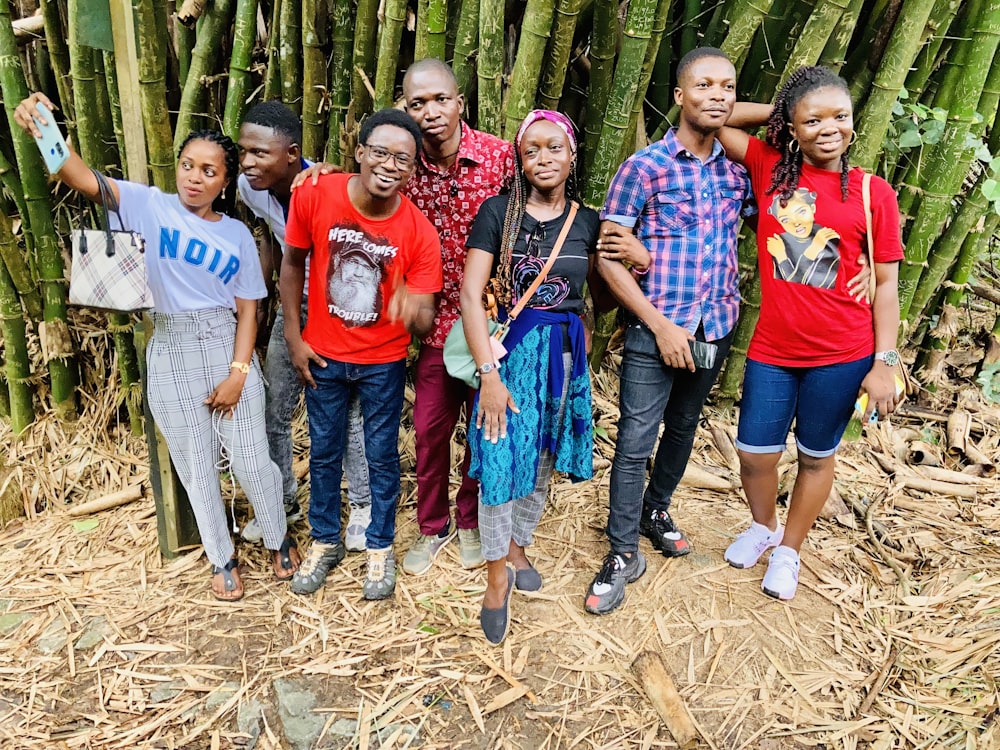 a group of people standing in front of a bamboo tree