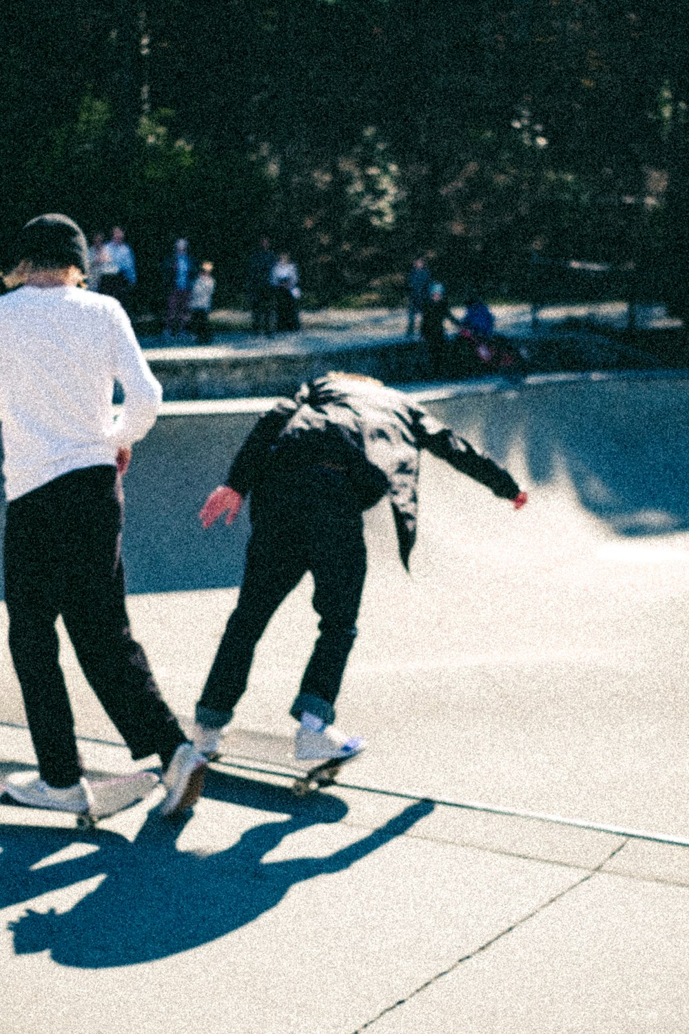 a couple of people riding skateboards at a skate park