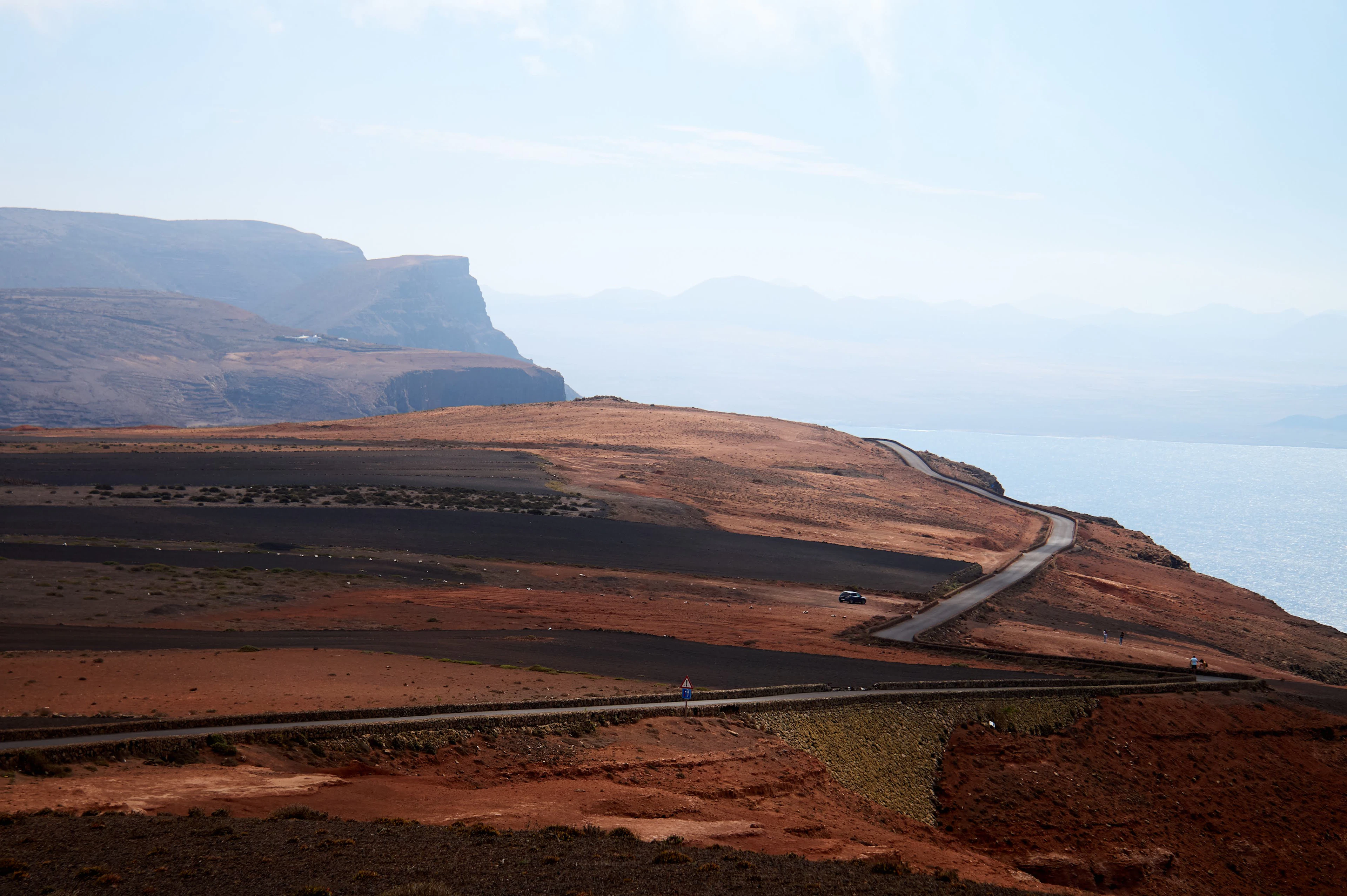 A road climbing a volcanic hillside in Lanzarote