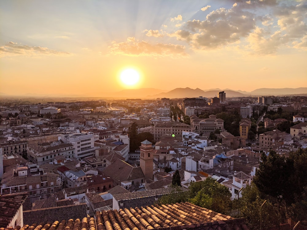 Il sole sta tramontando su una città con edifici alti