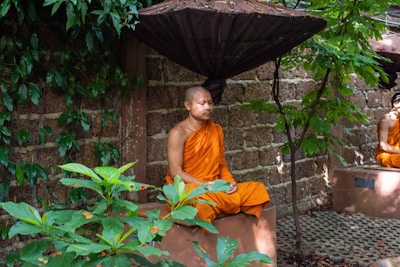 a man sitting on a bench under an umbrella