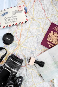 a map, camera, passport, and other items on a table