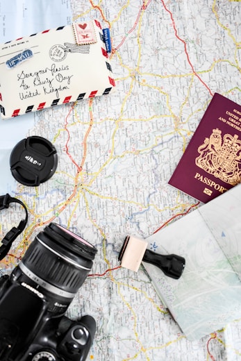 a map, camera, passport, and other items on a table