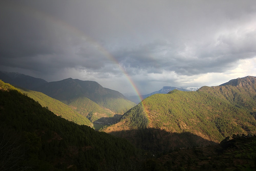 a rainbow in the sky over a mountain range