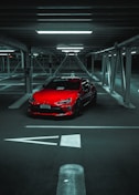 a red sports car parked in a parking garage