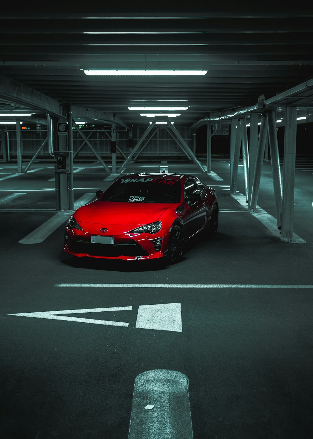 a red sports car parked in a parking garage
