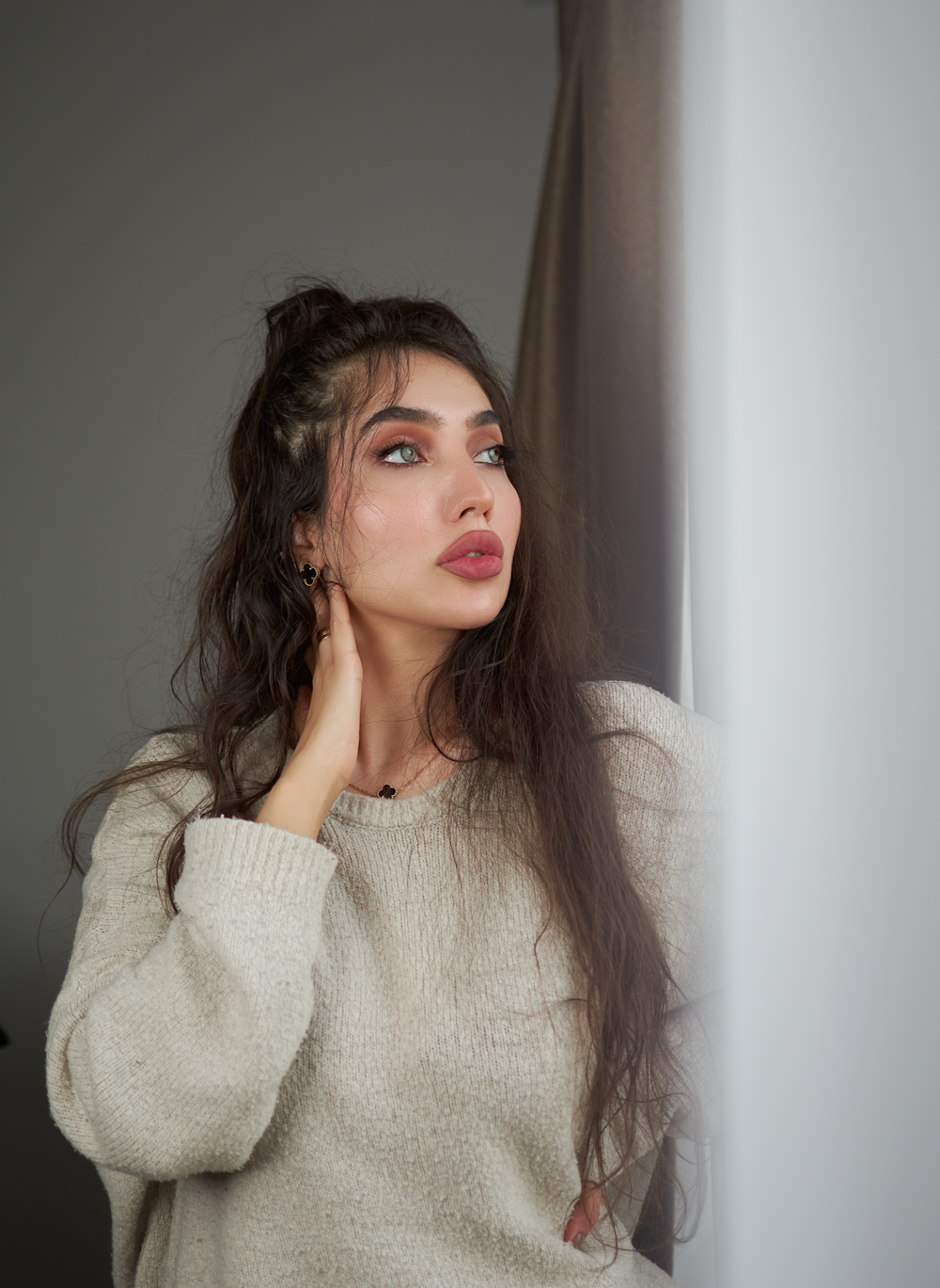 a woman with long dark hair wearing a white sweater