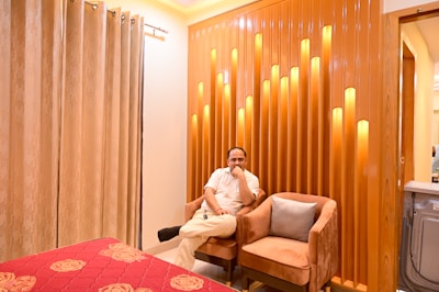 A man relaxing in a cozy, well-lit room wearing comfortable loungewear.