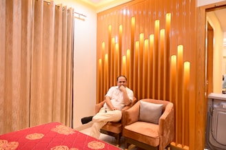 A man relaxing in a cozy, well-lit room wearing comfortable loungewear.