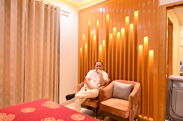 Elegant Moroccan businessman using a sleek home automation panel in a modern luxury living room.