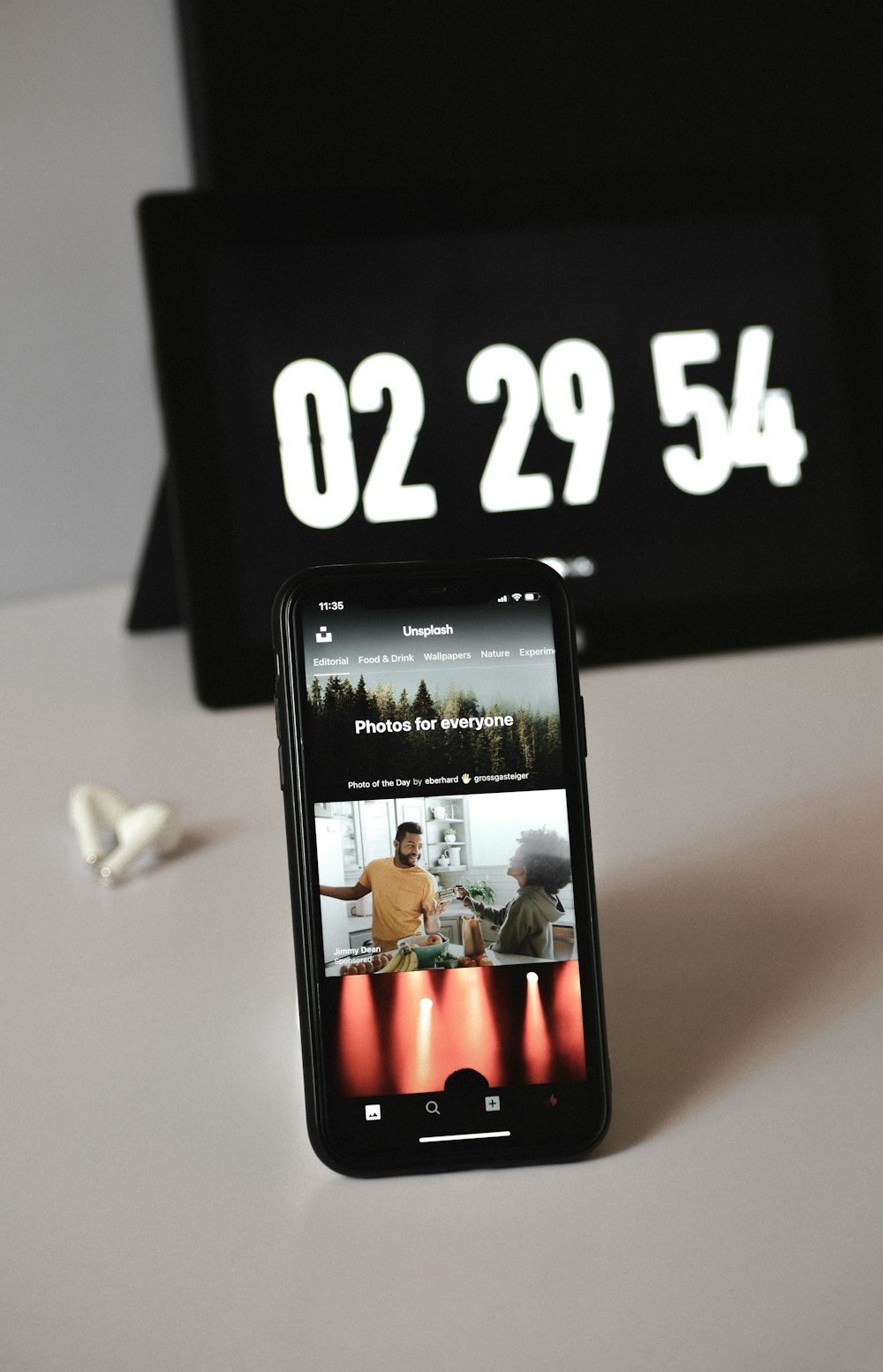 a cell phone sitting on top of a table next to a clock