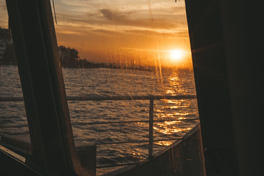 the sun is setting over the water from a boat