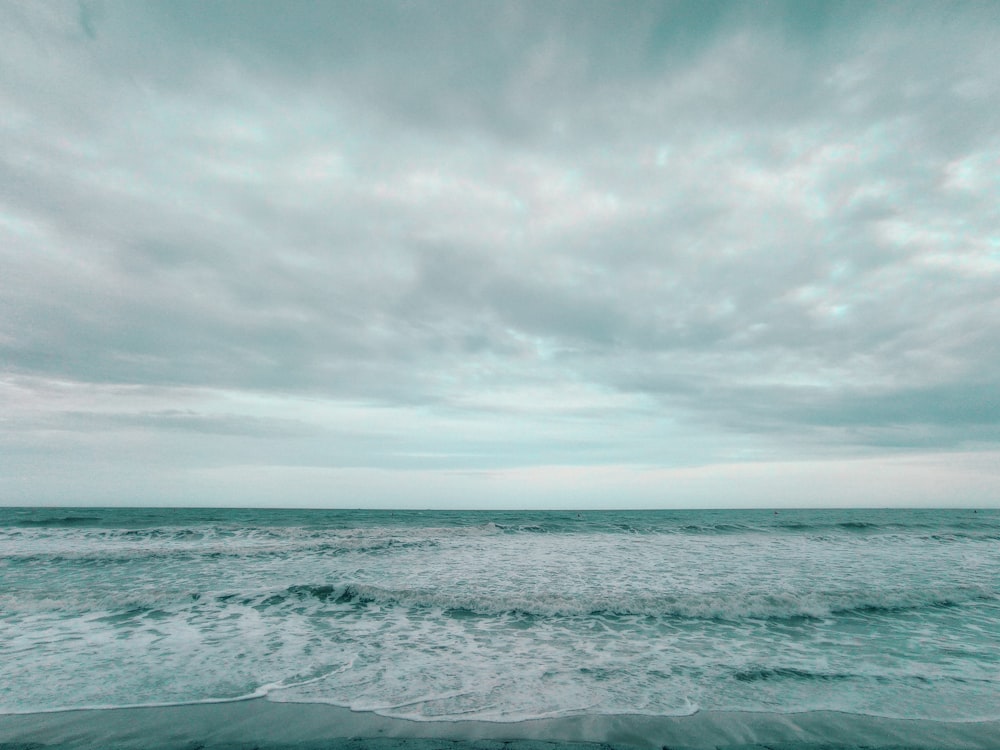 an ocean view with waves crashing on the shore