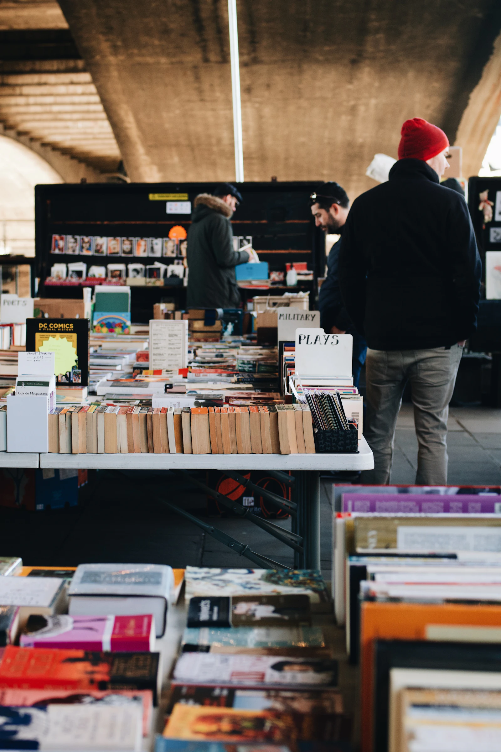 Travel photograph: Readers browsing tables of second-hand books beneath the concrete bridge on the South Bank.