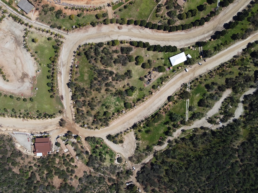 an aerial view of a dirt road in the middle of a forest