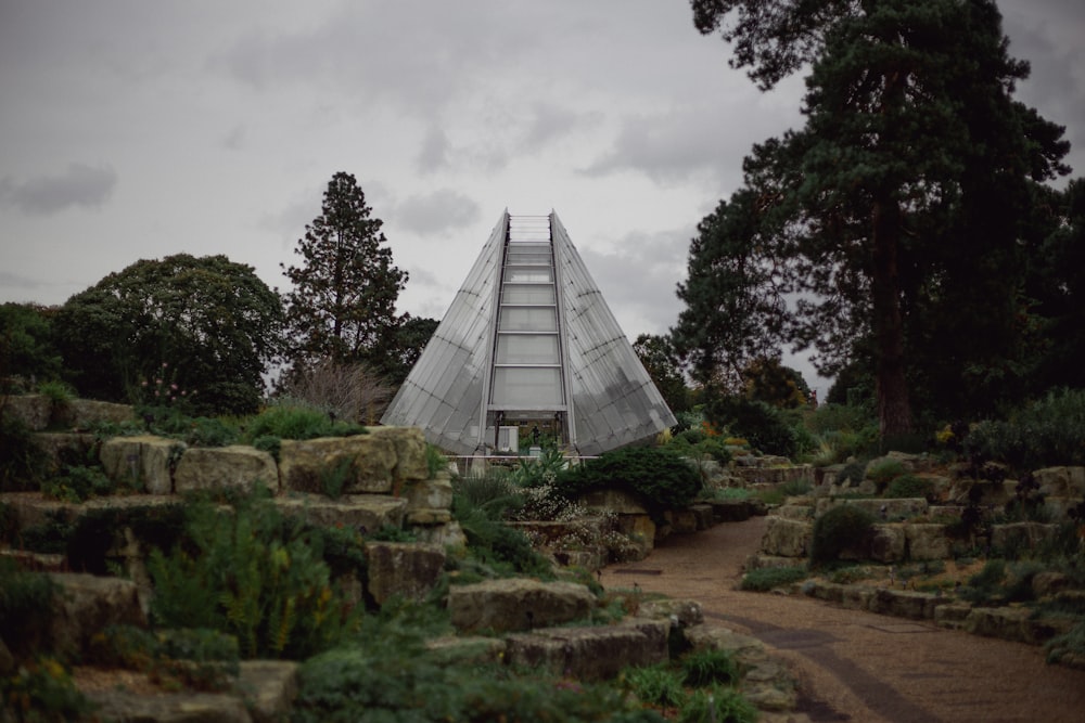 a pyramid shaped building surrounded by trees and rocks