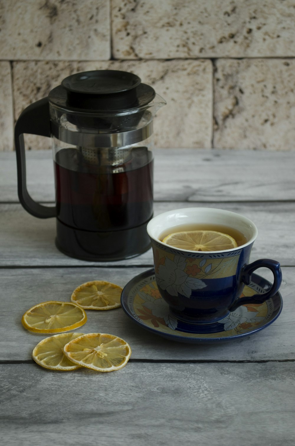 a cup of tea with lemon slices next to it