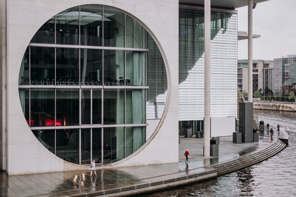 um edifício com uma janela circular ao lado de um corpo de água