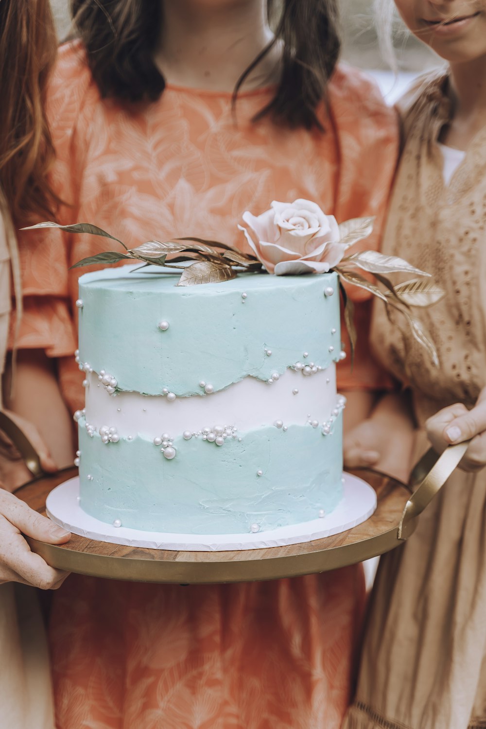 two girls holding a blue and white cake