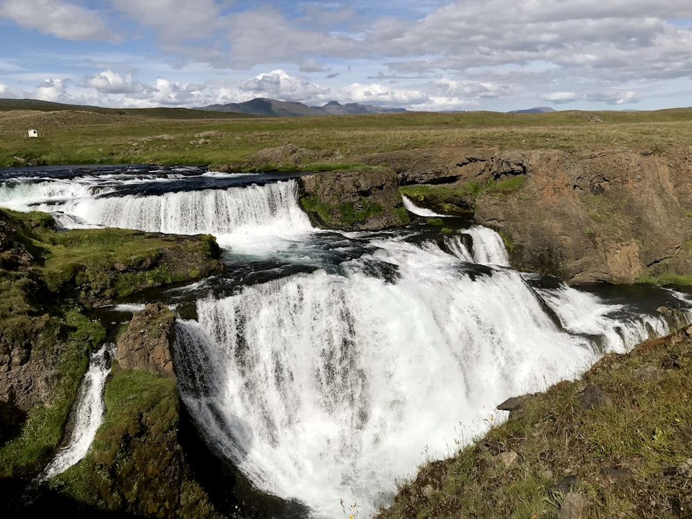 a large waterfall in the middle of a field