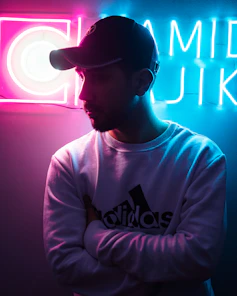 a man standing in front of a neon sign