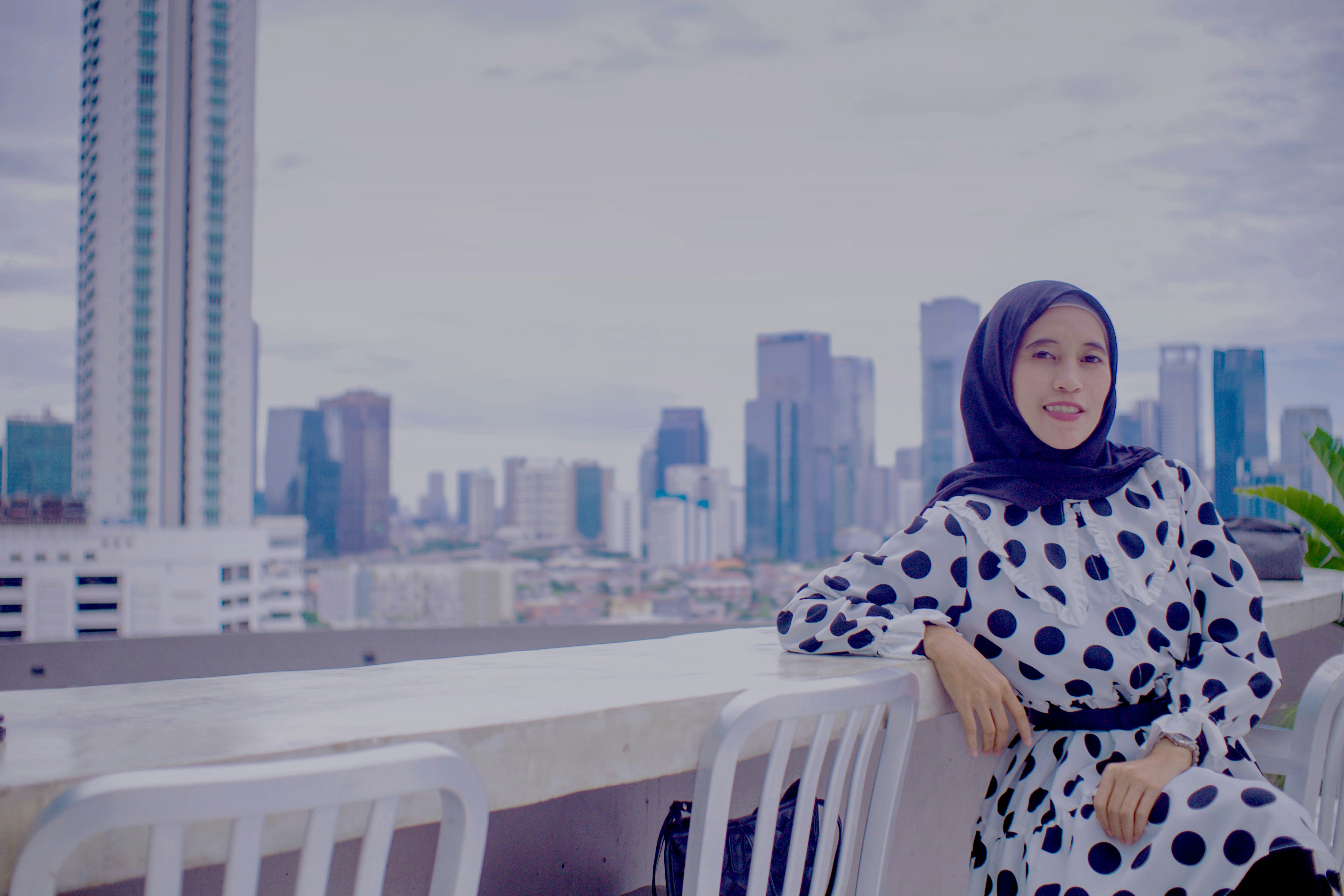 a woman in a polka dot dress standing on a balcony