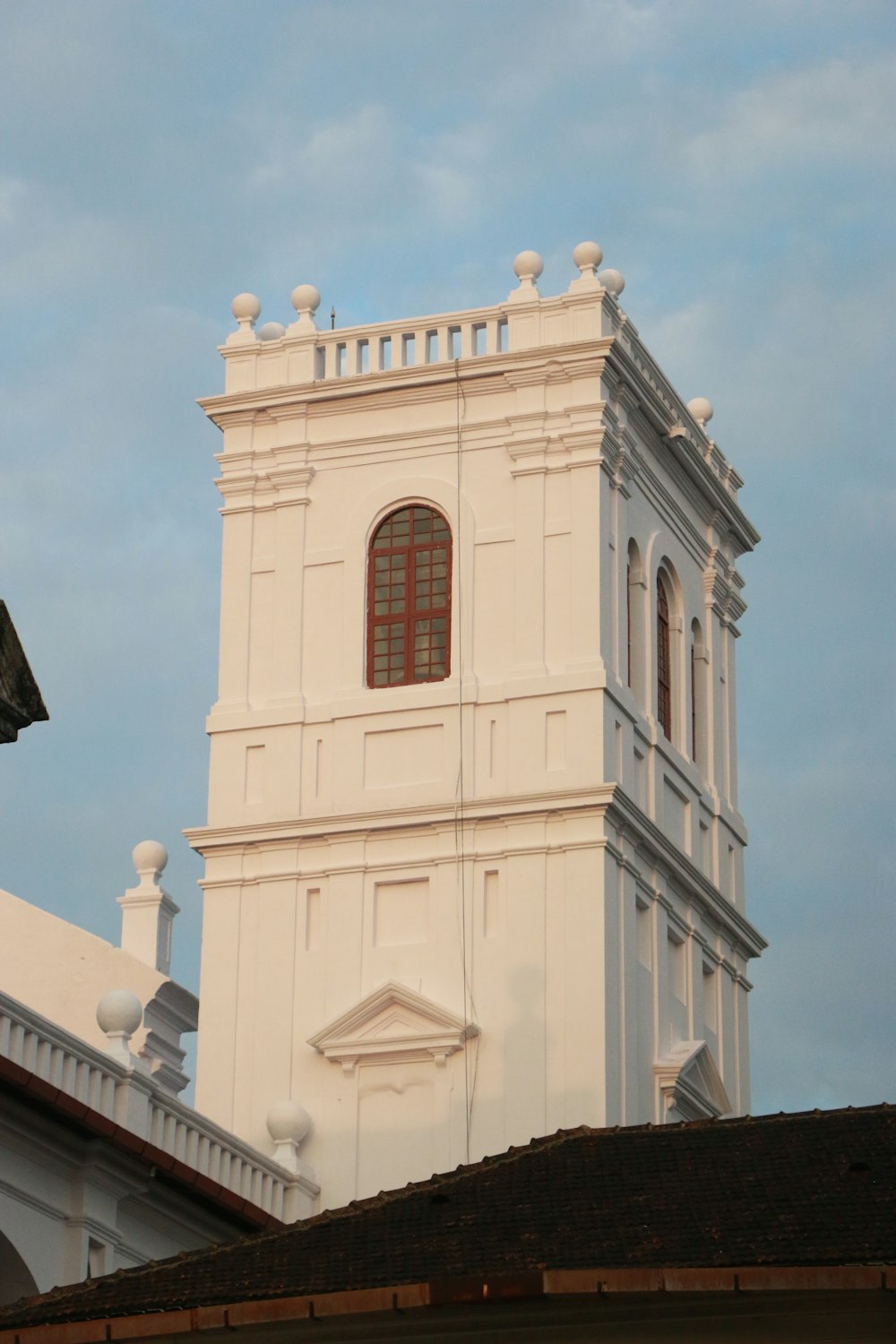 Ein hohes weißes Gebäude mit einer Uhr an der Seite