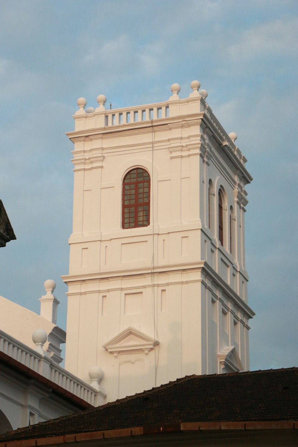 a tall white building with a clock on it's side