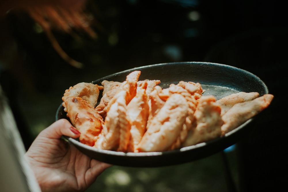 a person holding a bowl of food in their hand