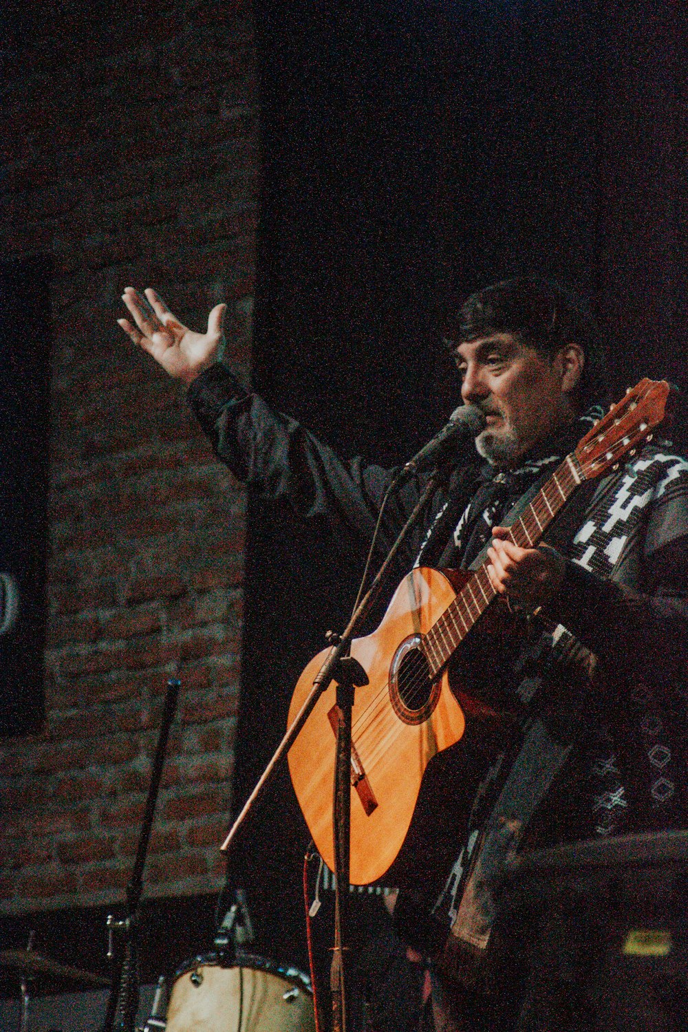 a man holding a guitar while standing next to a microphone