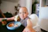 A happy toddler sitting at a high chair, reaching eagerly for a spoonful of colorful pureed food.