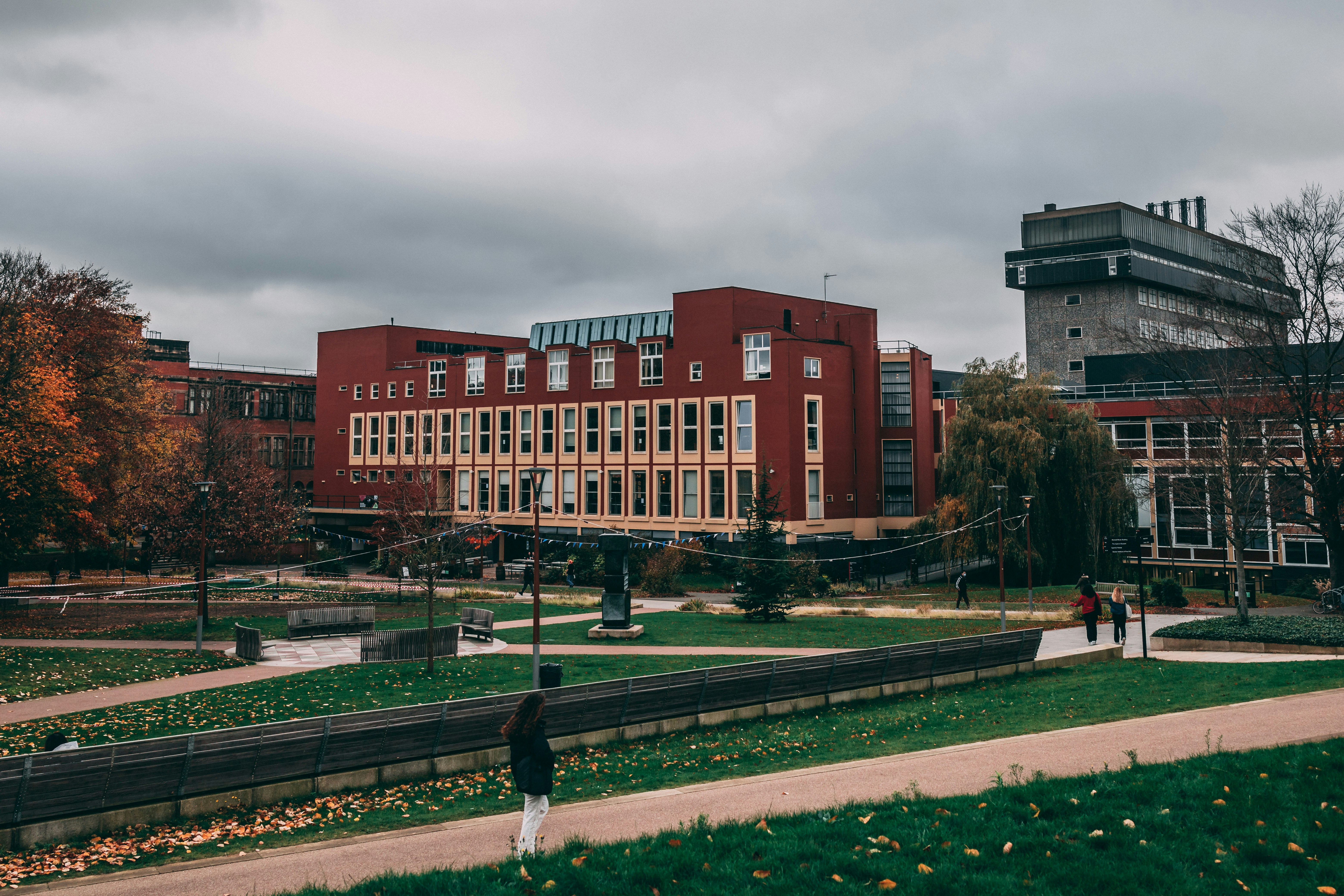 A person standing on a path in front of a building