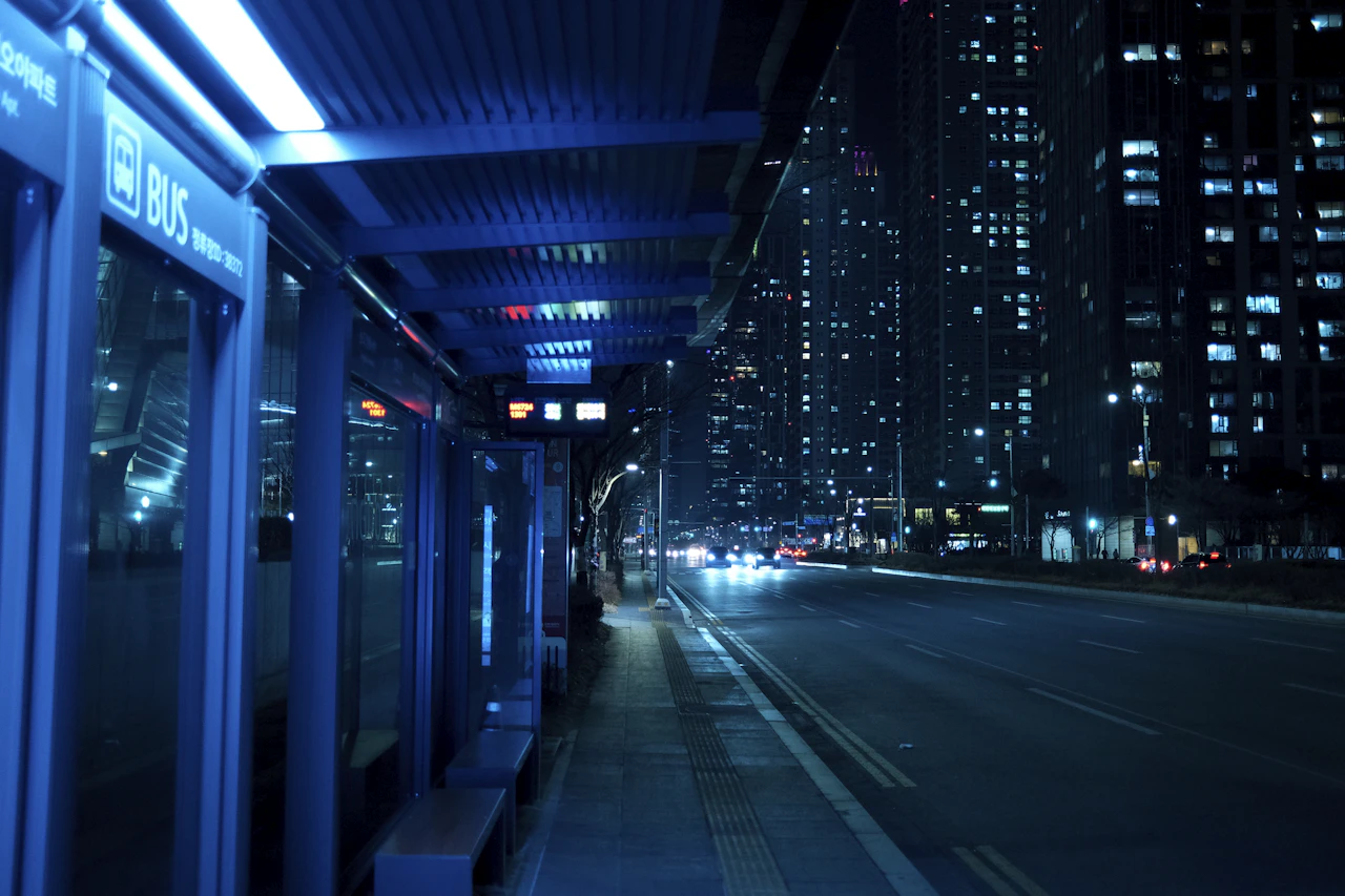 A city street at night with brightly lit buildings and light trails