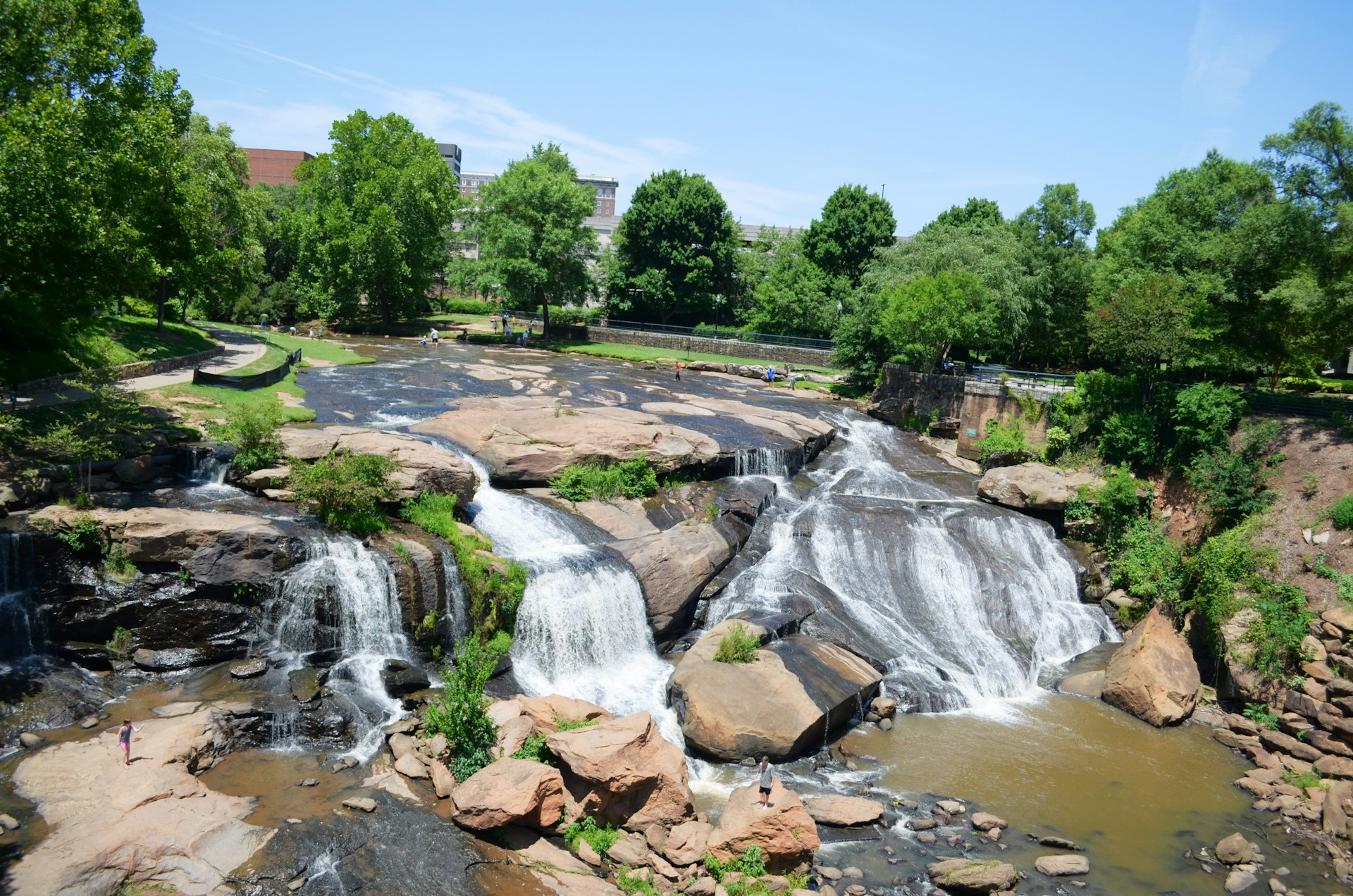 a waterfall in a park surrounded by trees