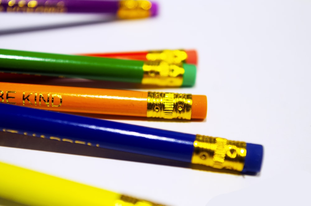 a group of colored pencils sitting next to each other