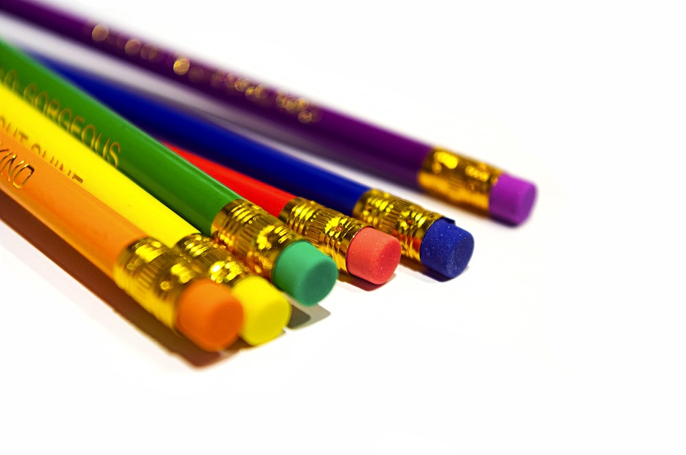 a group of colored pencils sitting next to each other