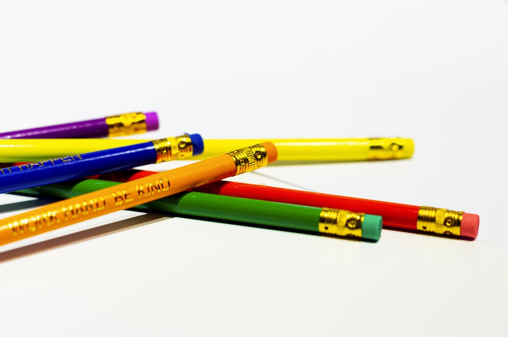 a group of colored pencils sitting on top of each other