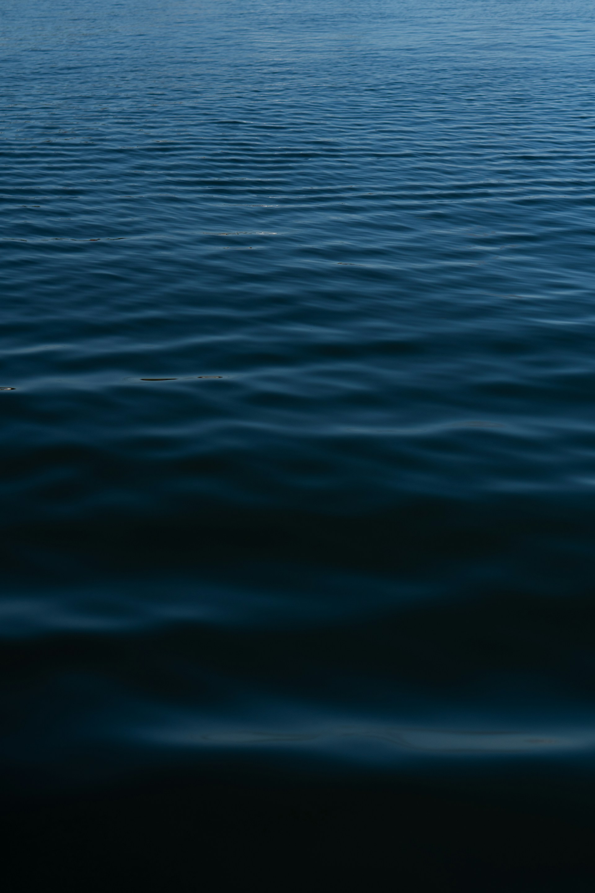 a large body of water with a boat in the distance