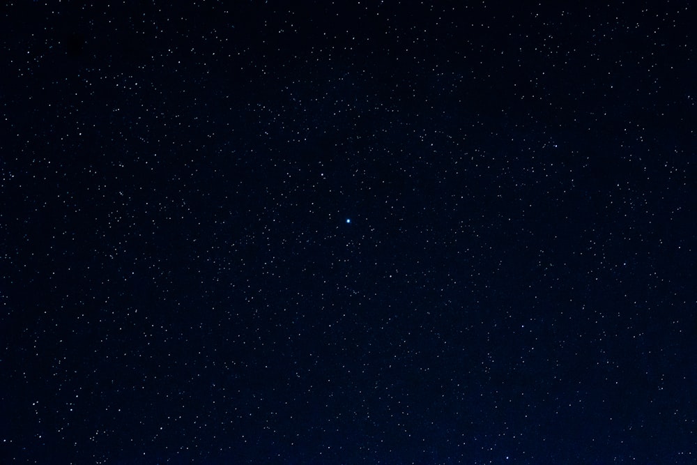 a night sky with a few stars and the moon