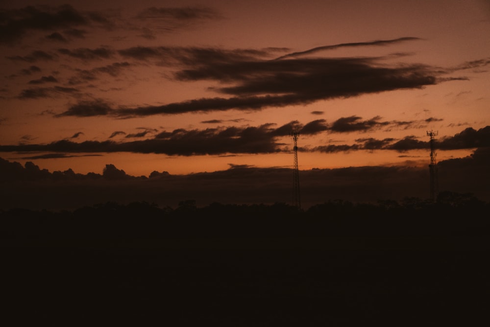 the sun is setting over the horizon of a field